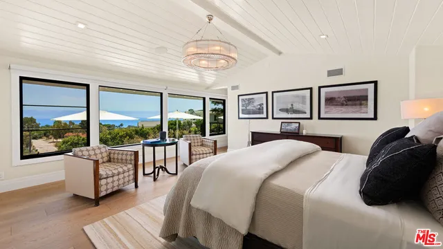 a spacious bedroom with a bed and a flat screen tv