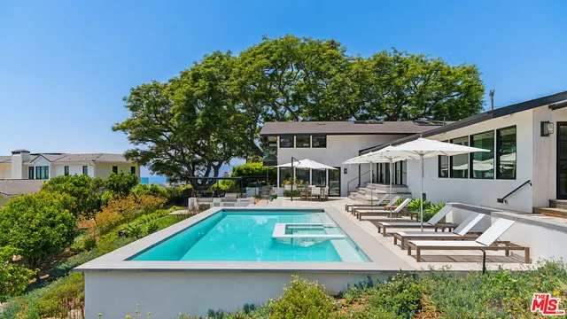 a patio with a table and chairs under an umbrella