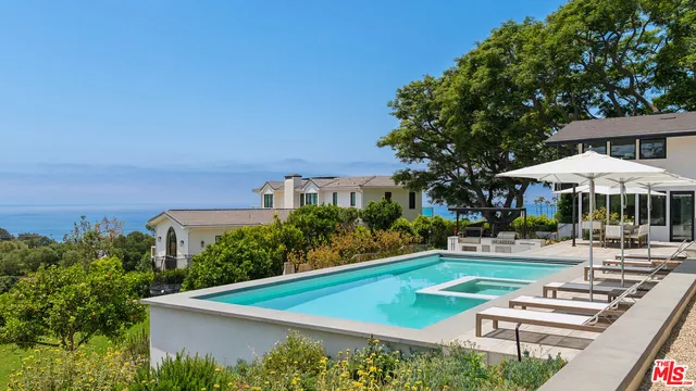 a view of a patio with couches chairs and a table and chairs with wooden fence