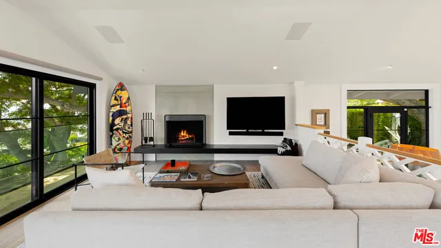 a living room with furniture flat screen tv and a large window