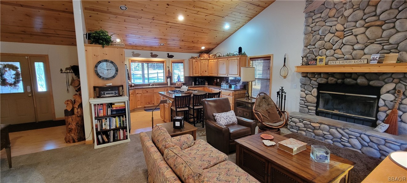 1685 Angels Camp Road Big Bear City, CA 92314 - Photo 5 of 35 a living room with furniture a fireplace and a table with wooden floor