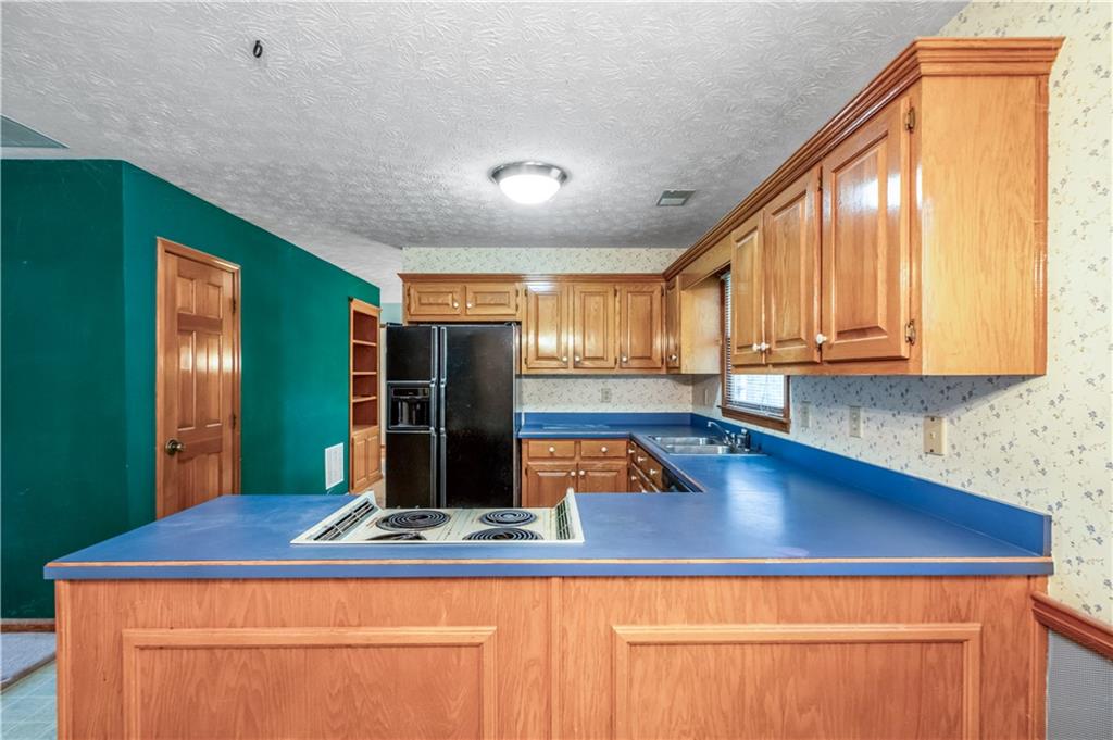 2177 Brooks Road Southeast Dacula, GA 30019 - Photo 11 of 42 a kitchen with stainless steel appliances granite countertop a sink window and cabinets