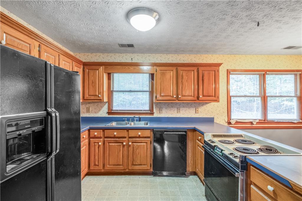 2177 Brooks Road Southeast Dacula, GA 30019 - Photo 13 of 42 a kitchen with a stove and a refrigerator