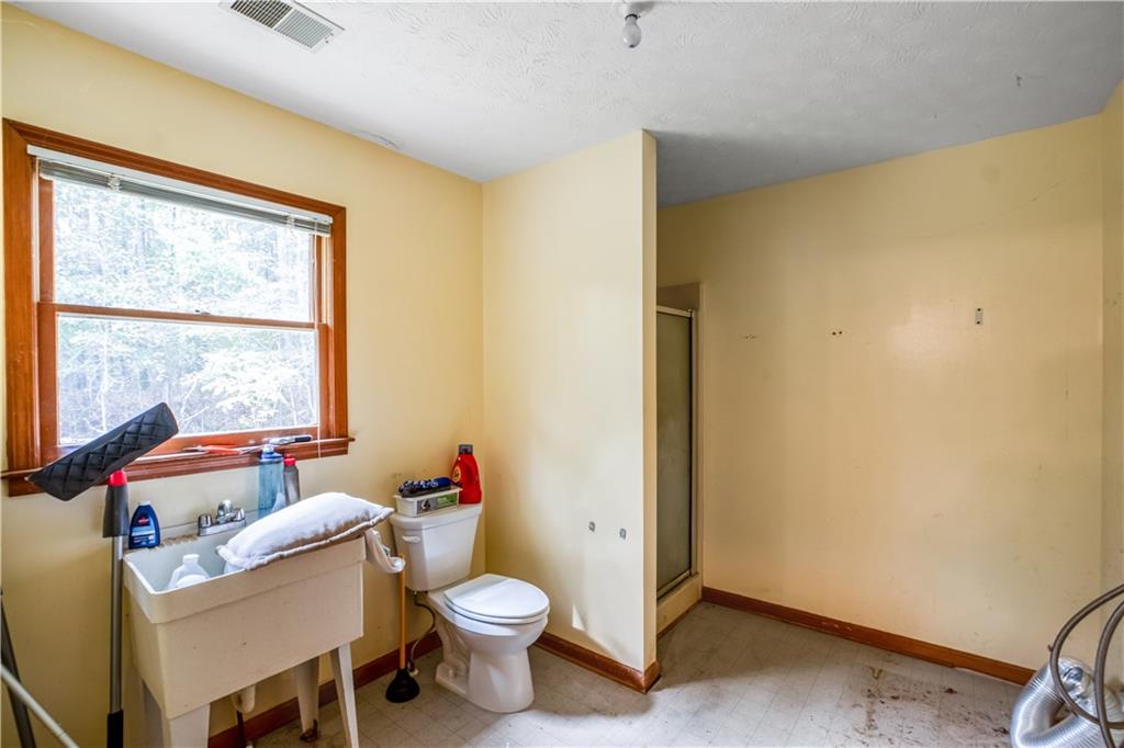 2177 Brooks Road Southeast Dacula, GA 30019 - Photo 15 of 42 a bathroom with a sink toilet and a tub