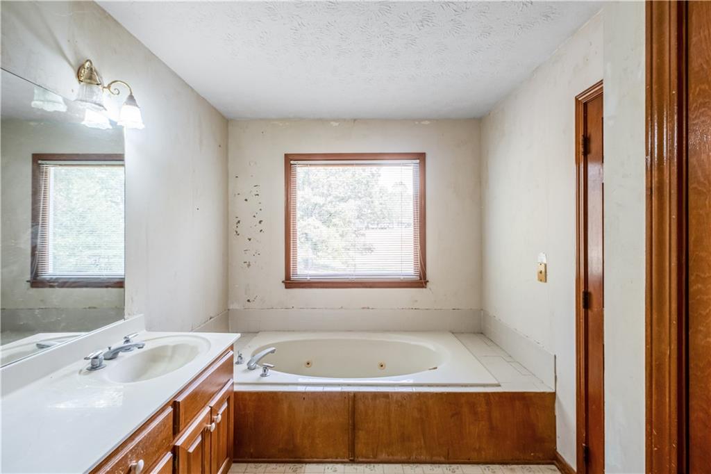 2177 Brooks Road Southeast Dacula, GA 30019 - Photo 19 of 42 a bathroom with a tub sink and mirror