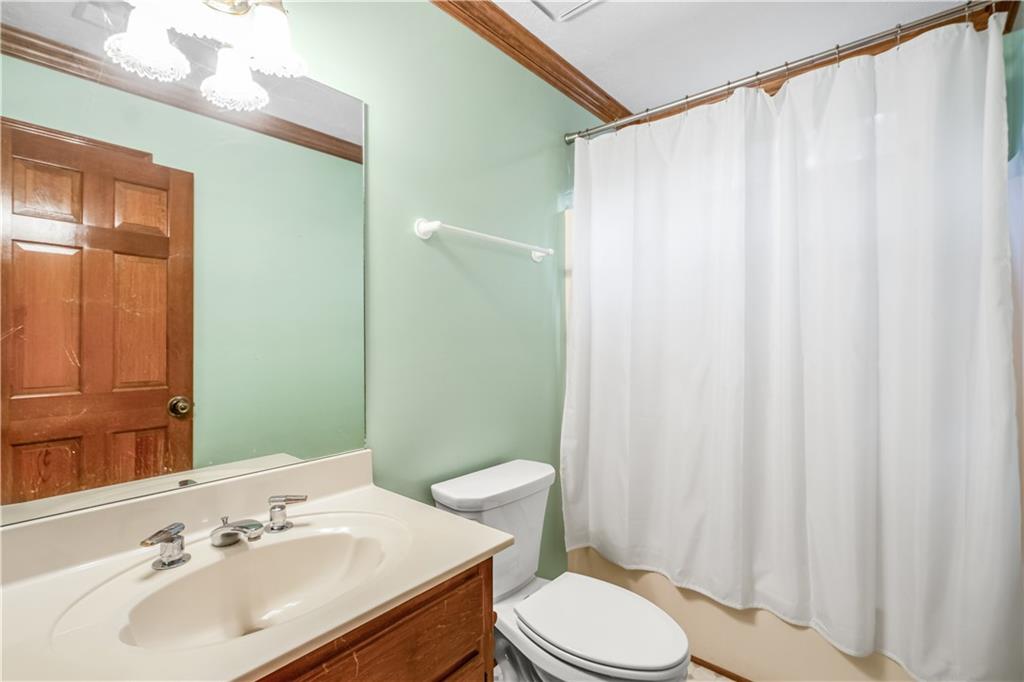 2177 Brooks Road Southeast Dacula, GA 30019 - Photo 22 of 42 a bathroom with a sink a toilet and shower curtain