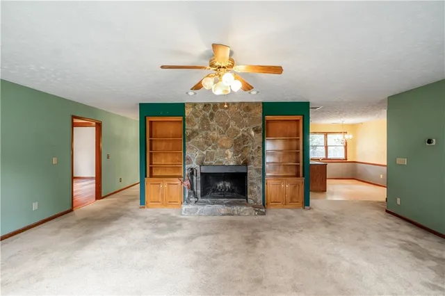 an empty room with fireplace cabinet and window