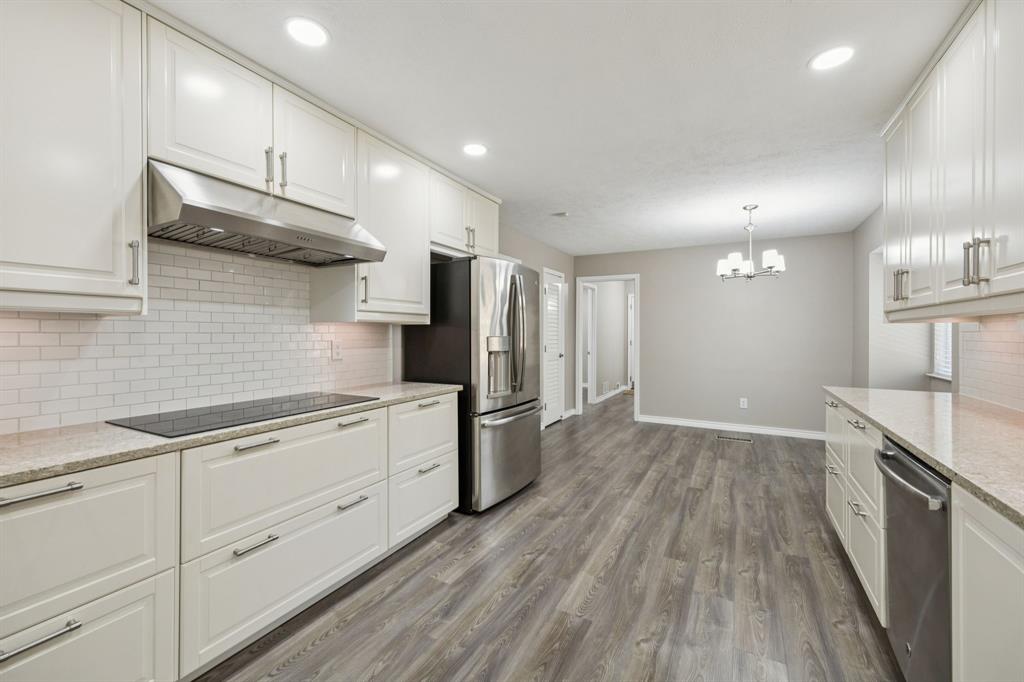 9536 Millridge Drive Dallas, TX 75243 - Photo 11 of 33 a kitchen with a sink stainless steel appliances wooden floor and cabinets