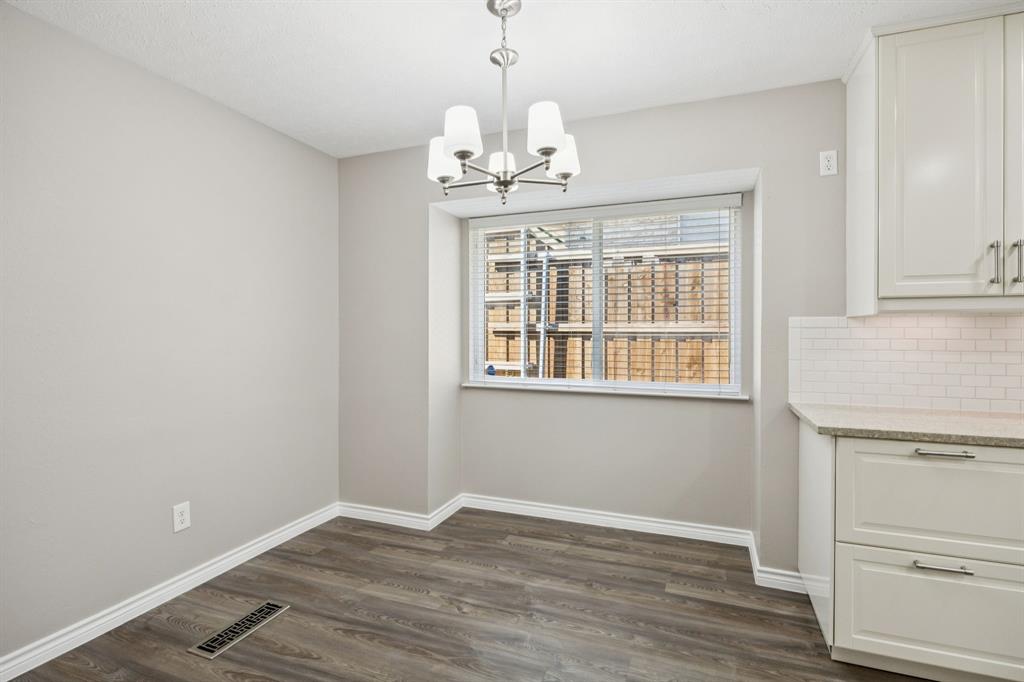 9536 Millridge Drive Dallas, TX 75243 - Photo 14 of 33 an empty room with wooden floor chandelier and windows