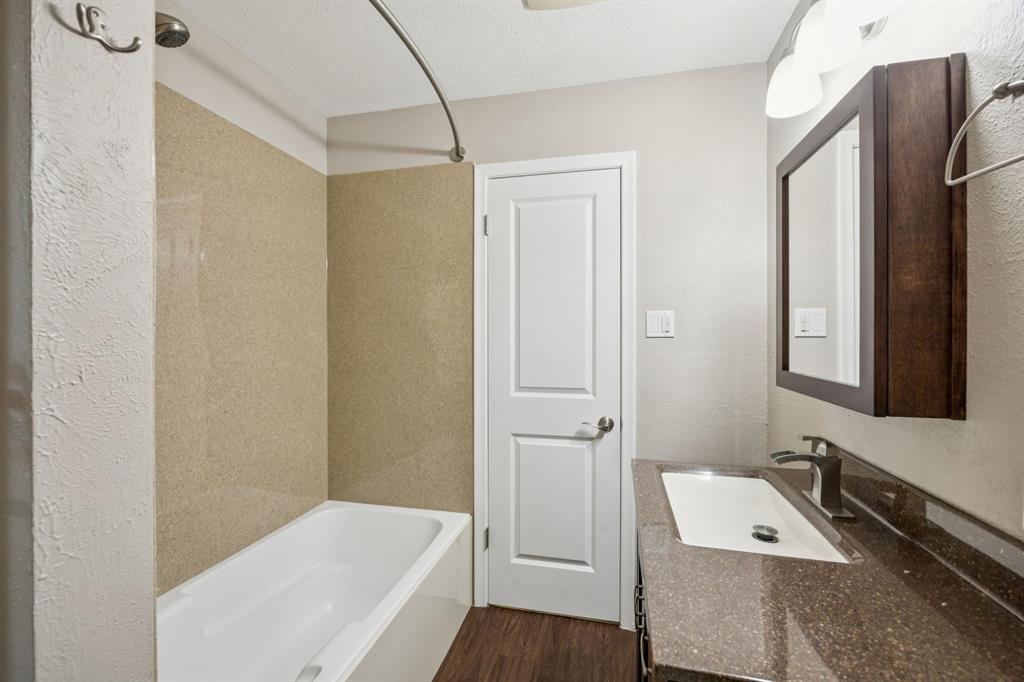 9536 Millridge Drive Dallas, TX 75243 - Photo 22 of 33 a bathroom with a tub a sink and mirror