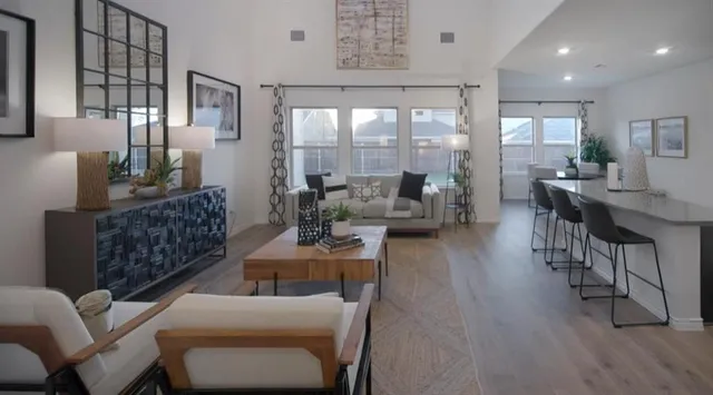 a living room with furniture wooden floor and a large window