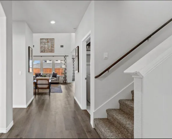 a kitchen with stainless steel appliances granite countertop a sink a stove a kitchen island with chairs and wooden floor