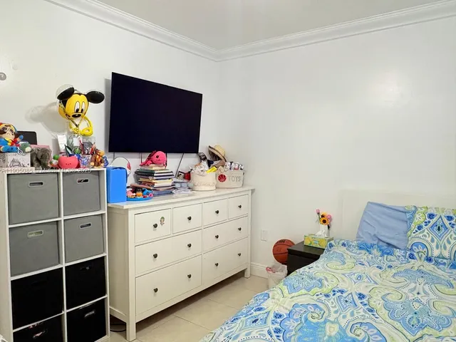 a bedroom with a bed dresser and a window