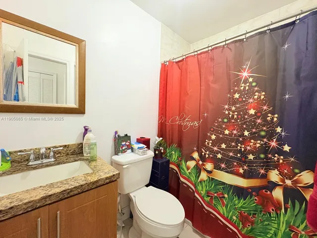 a white toilet sitting next to a bathroom sink and a mirror