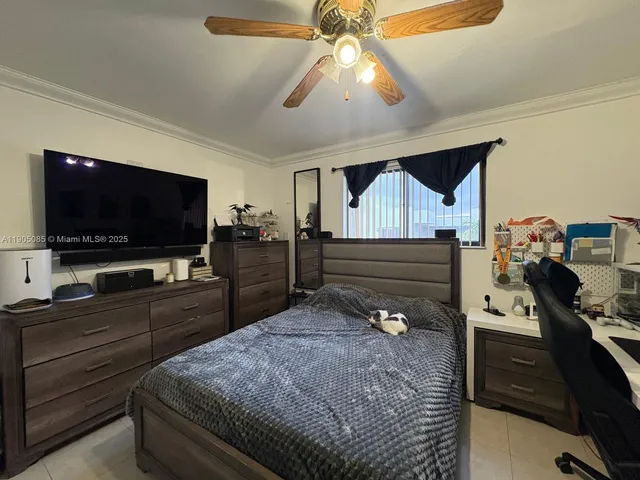 a bedroom with a bed and a flat tv screen on the dresser