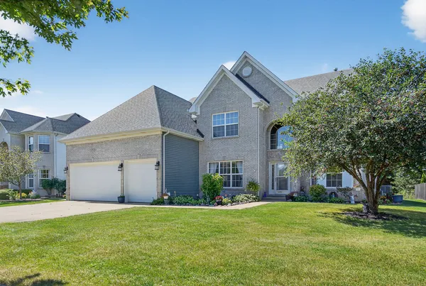 a front view of house with yard and green space
