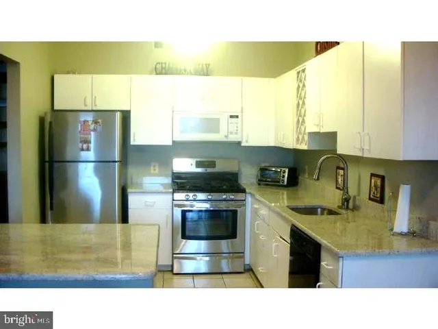 a kitchen with a sink a stove and a refrigerator