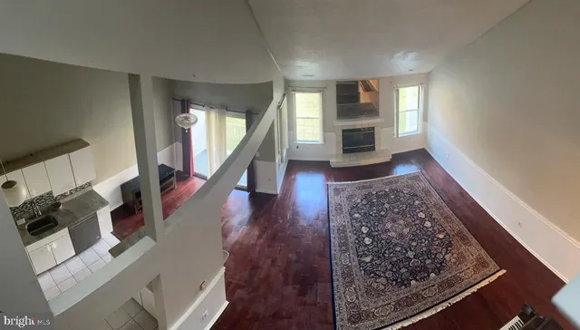 a living room with wooden floor furniture and a fireplace