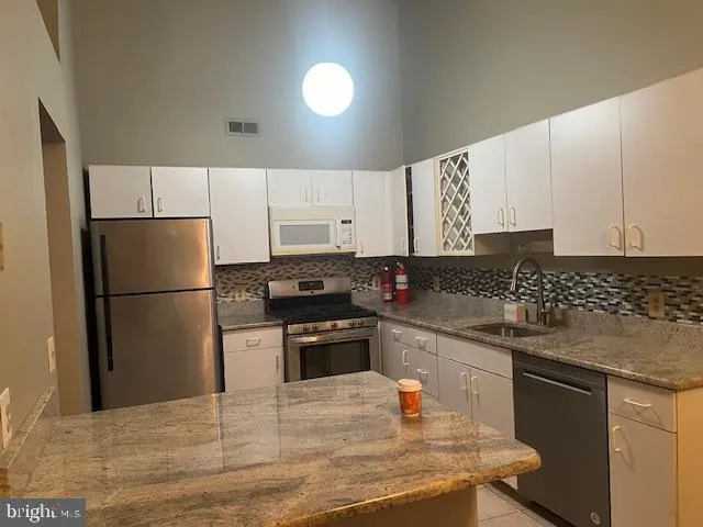 a kitchen with a sink a stove a refrigerator and a refrigerator