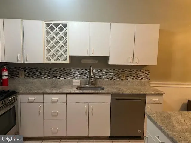 a kitchen with granite countertop white cabinets and sink