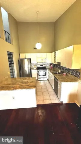 a open kitchen with granite countertop a stove and a refrigerator