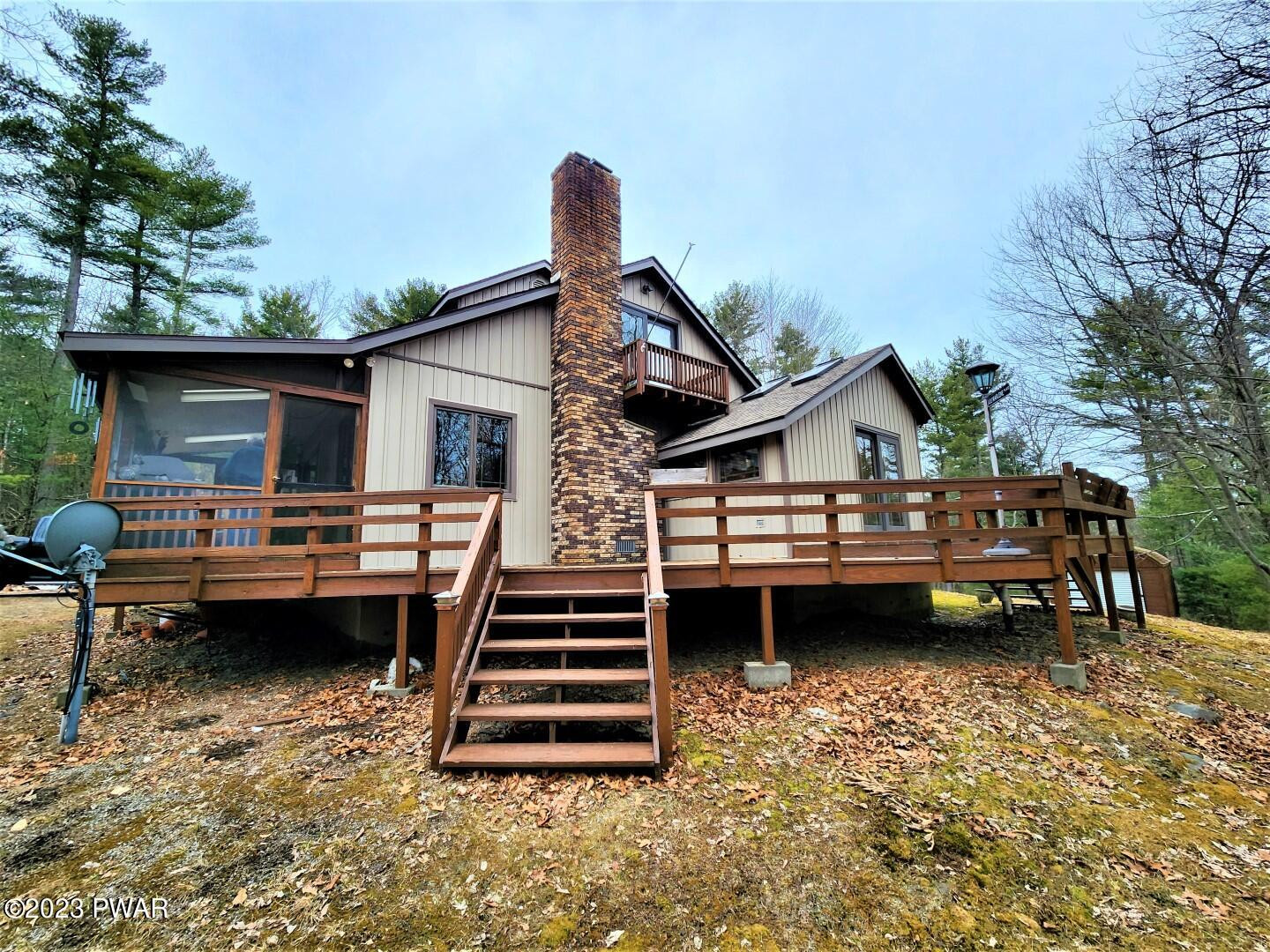 114 Rim Rock Road Milford, PA 18337 - Photo 2 of 25 a view of a house with a balcony and wooden floor