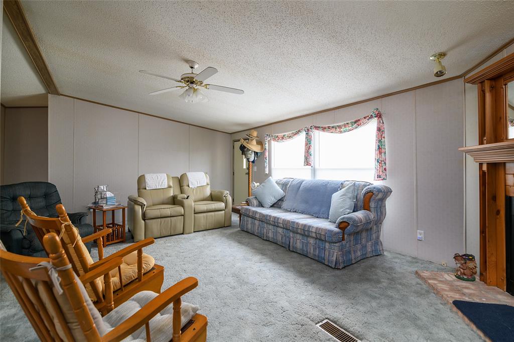 122 Grice Road Ringgold, LA 71068 - Photo 10 of 26 Living area featuring a ceiling fan with light fixture, light-toned wall paneling, and a floor vent