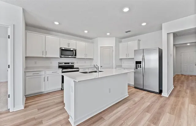 a kitchen with stainless steel appliances a refrigerator stove and microwave