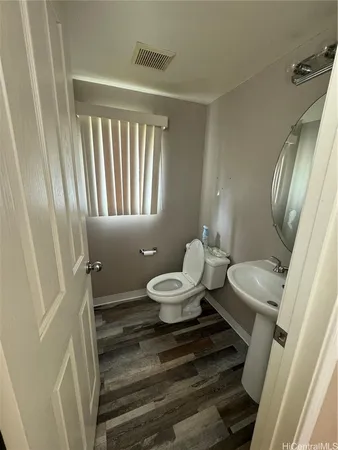 a bathroom with a toilet sink a mirror and a window