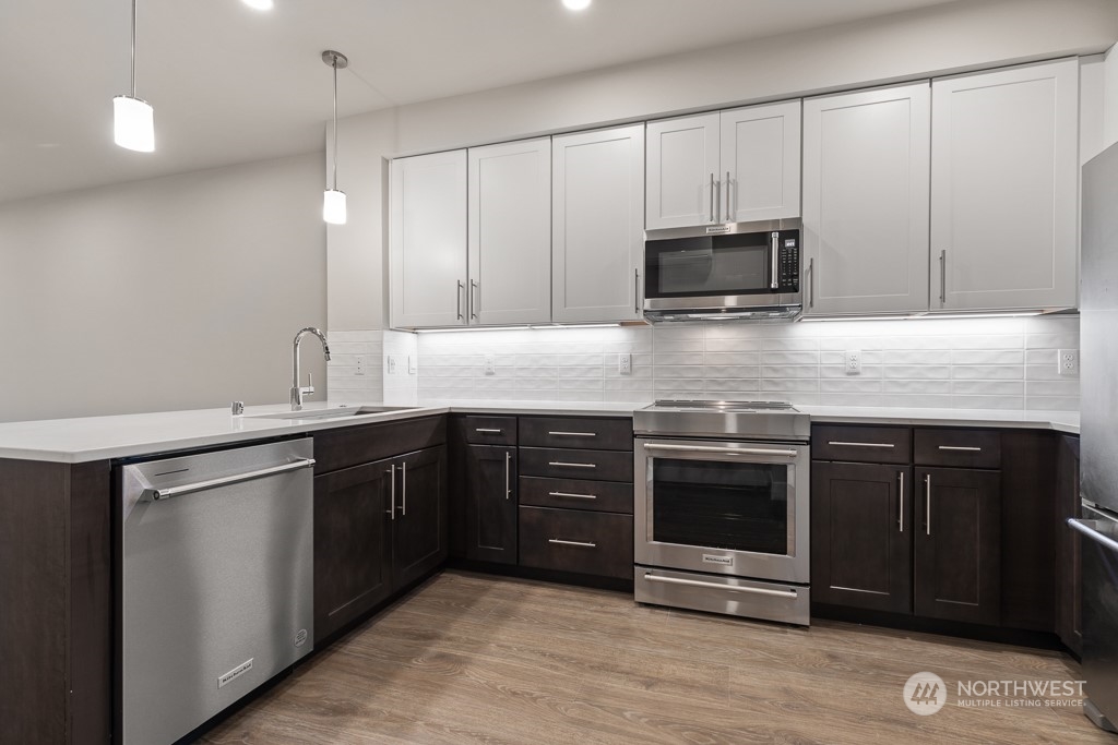826 238th Place Southeast, Unit B 14 Bothell, WA 98021 - Photo 12 of 32 a kitchen with stainless steel appliances granite countertop a stove and a microwave