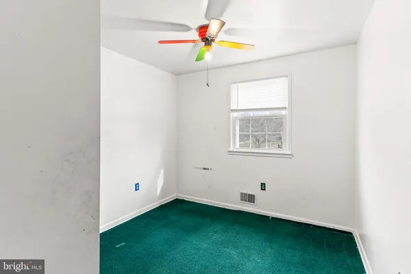 a view of an empty room with window and cabinet