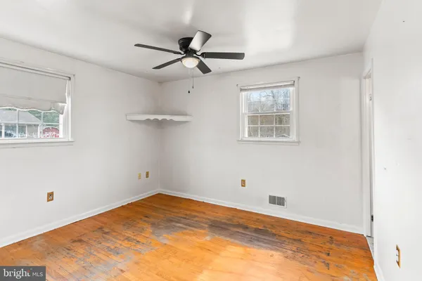 a view of empty room with wooden floor