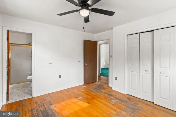 a bedroom with a bed and a chandelier fan