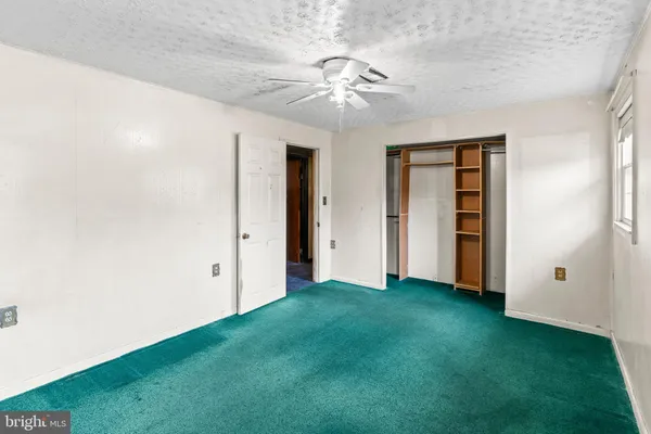 an empty room with closet and fan