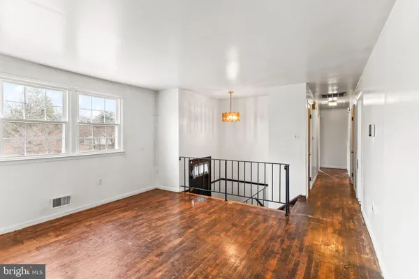 a view of a room with wooden floor and windows