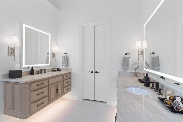 a spacious bathroom with double vanity sinks a large mirror and a bathtub