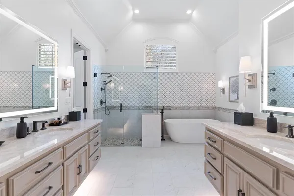 a bathroom with a tub a double vanity sink and mirror