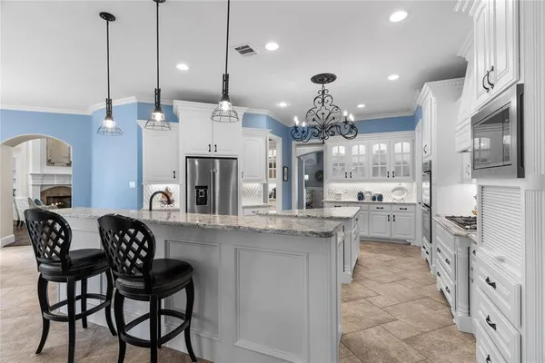 a kitchen with stainless steel appliances granite countertop a refrigerator and a sink