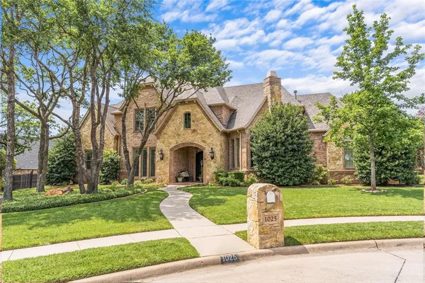 a front view of a house with a yard garden and tree