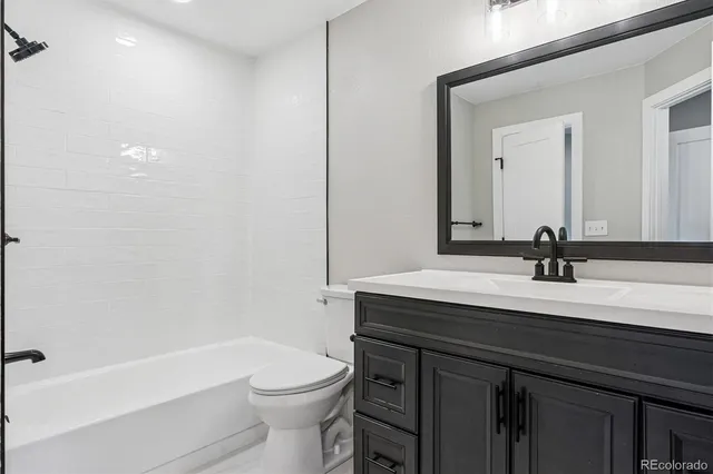 a bathroom with a sink a toilet a mirror and shower