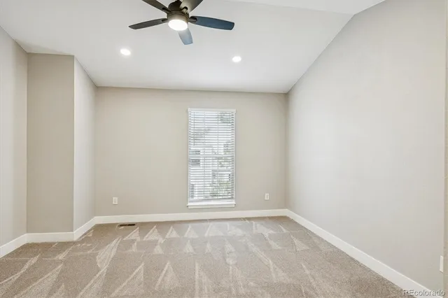 an empty room with a window and a fan