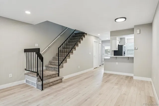 a view of a hallway with wooden floor and staircase