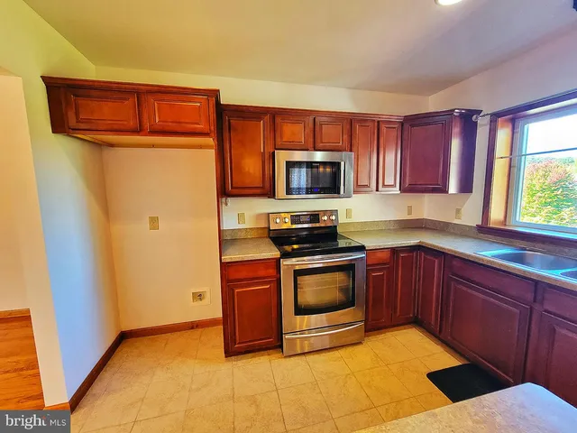 a kitchen with stainless steel appliances granite countertop a stove microwave and sink