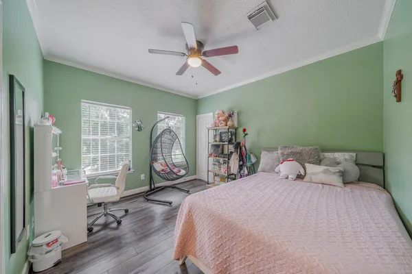 a bedroom with a bed a table and painting on the wall
