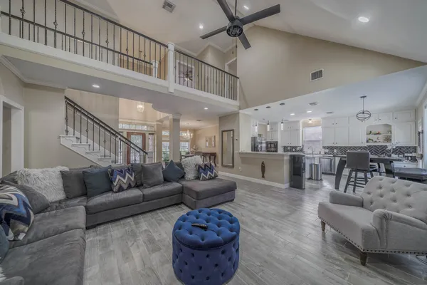 a living room with furniture kitchen view and a large window