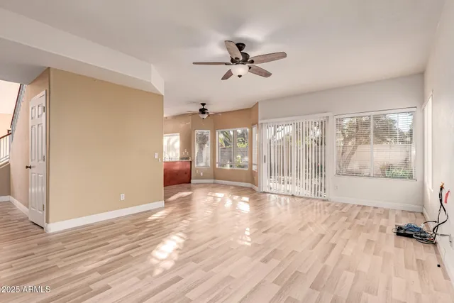 a view of an empty room with a window and wooden floor