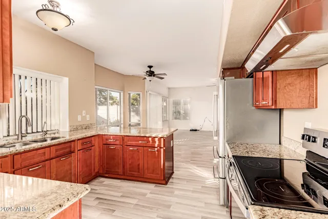 a large kitchen with stainless steel appliances granite countertop a stove and a sink