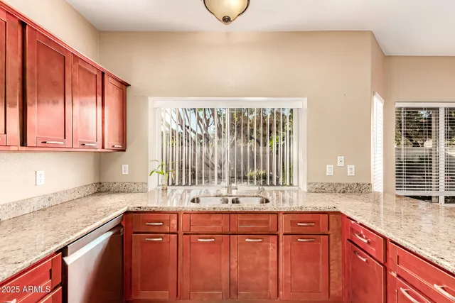 a kitchen with stainless steel appliances granite countertop a sink and a wooden cabinets