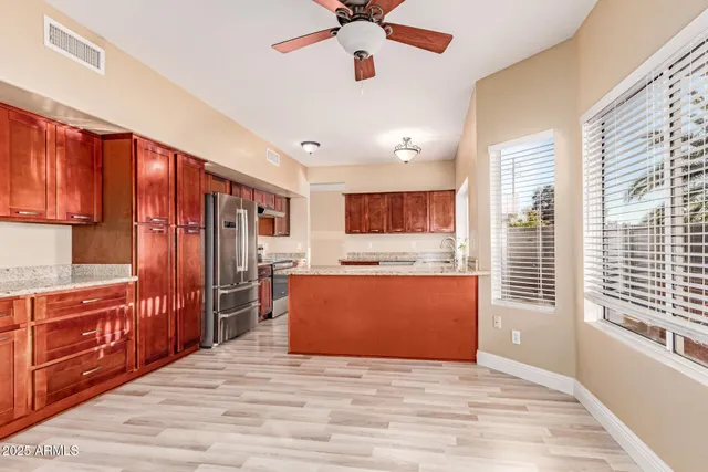a view of kitchen with stainless steel appliances granite countertop a refrigerator a sink dishwasher a stove and a refrigerator