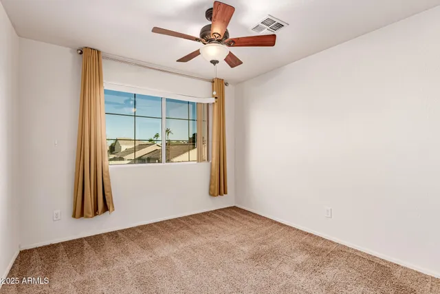 a view of a room with a ceiling fan and a rug